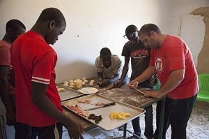 Jorge Reina (right), a Venezuelan bread maker, shows a group of young men how to prepare dough to be baked. A former drug smuggler who met Christ, Reina moved to Senegal a year ago to feed boys, teach them bread-making skills and disciple them.