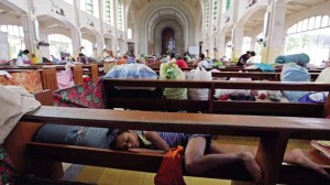 A child uses a pew as a makeshift bed inside the Redemptorist Church in Tacloban City where residents evacuated ahead of the landfall of Typhoon “Ruby”