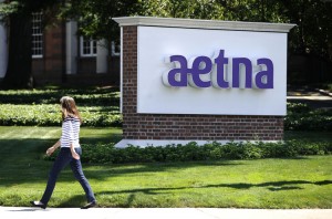 FILE - In this Tuesday, Aug. 19, 2014, file photo, a pedestrian walks past a sign for health insurer Aetna Inc., at the company headquarters in Hartford, Conn. Aetna Inc. reports financial results Tuesday, Aug. 2, 2016. (AP Photo/Jessica Hill, File)