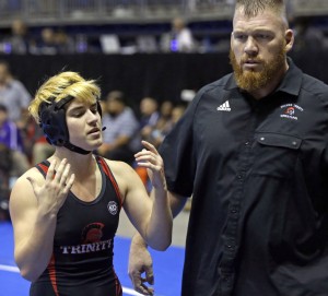 Mack Beggs, left, a transgender wrestler from Euless Trinity High School, stands with his coach Travis Clark during a quarterfinal match against Mya Engert, of Amarillo Tascosa, during the State Wrestling Tournament, Friday, Feb. 24, 2017, in Cypress, Texas. Beggs was born a girl and is transitioning to male but wrestles in the girls division. ( Melissa Phillip/Houston Chronicle via AP) ORG XMIT: TXHOU901